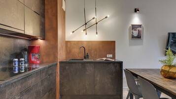 Una cocina moderna con una isla central, cafetera y comedor con mesa y sillas.
