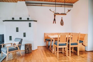 A cozy room with a wooden dining table, chairs, a sofa, and a unique wall decoration. - Family-friendly apartment with a terrace and a cozy living area (Sankt Michael im Lungau)