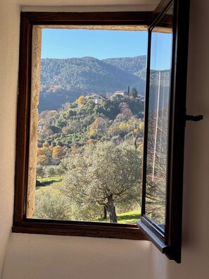 A window with a view of a hilly landscape with trees and a clear sky. - L'Échappée Nature, a 17th-century Cévennes farmhouse—rated 3 stars (Les Vans)