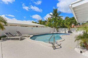 A swimming pool with lounge chairs, a poolside area, and palm trees. - Studio on the Barrier Island. Walk to the Beach (Fort Lauderdale)