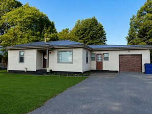 Einbungalow mit Garage, Eingangstür und kleiner Veranda.