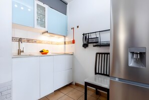 A modern kitchen with white cabinets, a stainless steel refrigerator, and a fruit bowl on the counter. - Vacation Home 'Studio in Las Americas K106' with Wi-Fi (Arona)