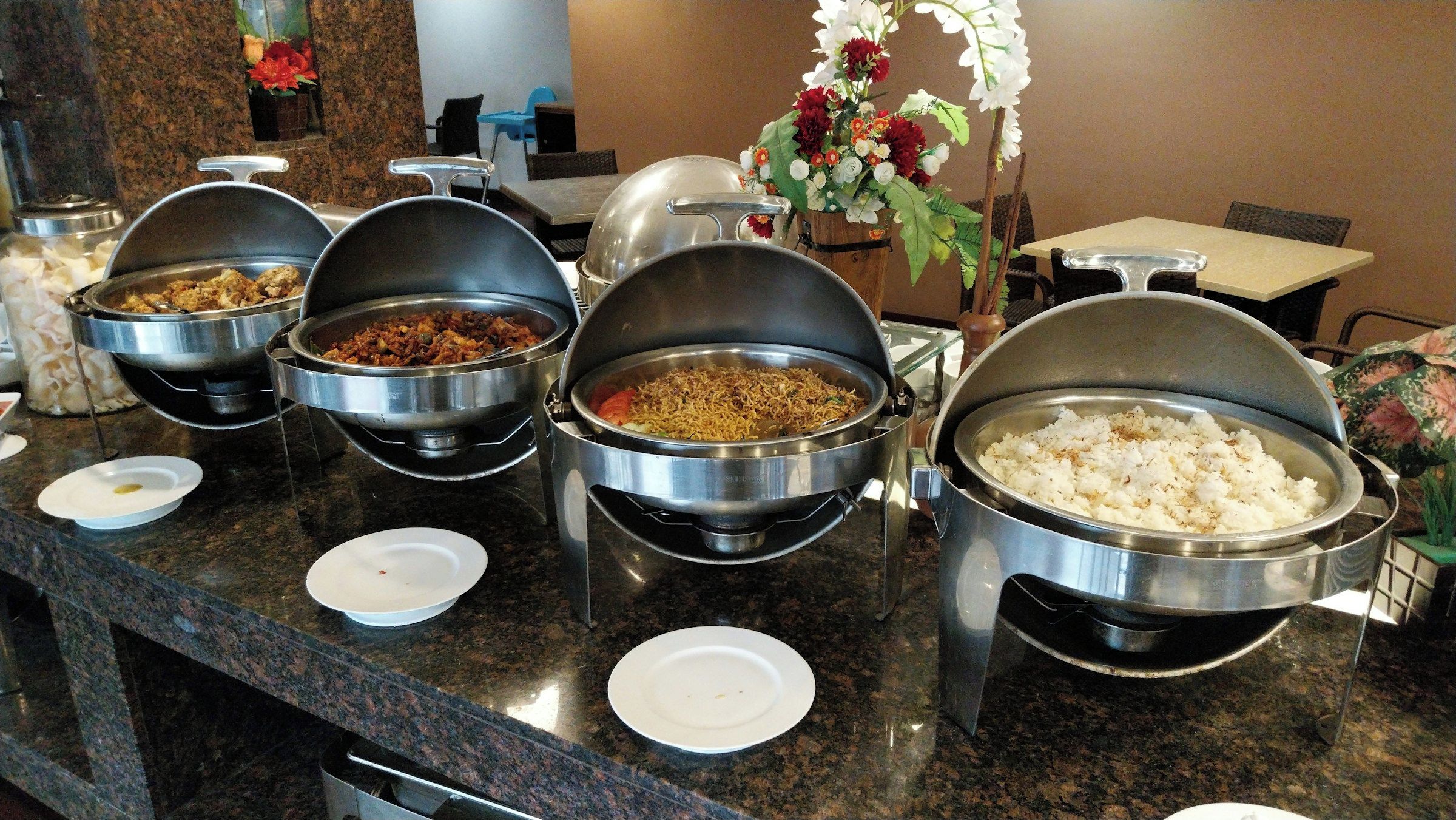 A buffet setup with various dishes in metal serving containers.