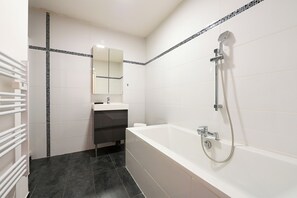 A modern bathroom with a bathtub, a shower, a mirror, and a towel rack. - Villa contemporaine 7 minutes du Centre de Lille (Marcq-en-Barœul)