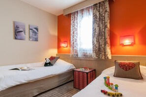 A hotel room with two beds, a window with curtains, wall-mounted lights, and a small table with toys. - Wifi, 10m from ski slopes, fitness, swimming pool, sauna, hammam, balcony, ski locker, 63-68m² (Avoriaz)
