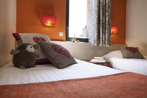 A hotel room with two beds, each with a heart-patterned pillow, a plush toy on one bed, and a window with curtains. - Wifi, 10m from ski slopes, view mountain, fitness, swimming pool, sauna, hammam, balcony, ski locker (Avoriaz)