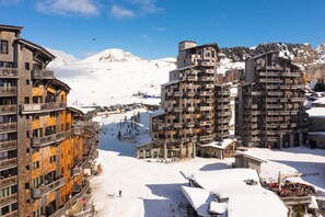 A snow-covered ski resort with multi-story buildings featuring balconies and ski lifts in the background. - Wifi, 10m from ski slopes, view mountain, fitness, swimming pool, sauna, hammam, balcony, ski locker (Avoriaz)