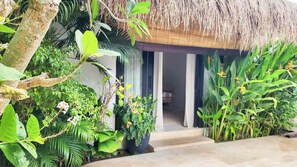 A tropical resort entrance with a thatched roof, lush greenery, and a stone pathway leading to the door. - Villa Drifter-Canggu Newly Renovated Private Villa (Kecamatan Kuta Utara)