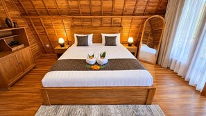 Habitación con paneles de madera, una cama grande, mesitas de noche con lámparas y un armario.