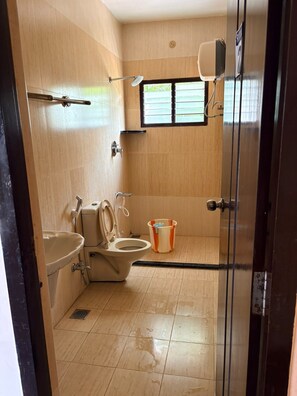 Une petite salle de bain comprenant des toilettes, un lavabo et un espace douche.