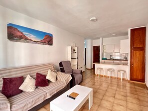 Ein Wohnzimmer mit einer Couch, einem Couchtisch und einem Gemälde an der Wand.