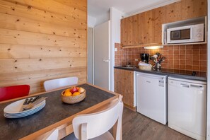 A compact kitchen with wooden cabinets, a microwave, a sink, and a dishwasher. - 10m from ski slopes, balcony, ski locker, 20-22m², Avoriaz (Avoriaz)
