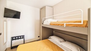 Una cama litera con un televisor montado en la pared superior.
