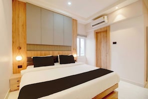 Un dormitorio moderno con una cama grande, armario empotrado y aire acondicionado.