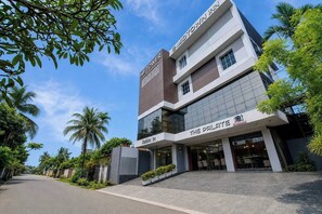 A modern hotel building with a sign for 'HB Tower' and 'The Palate Restaurant' on the ground floor. - Palette Boragaon Formerly Midtown Inn (Guwahati)