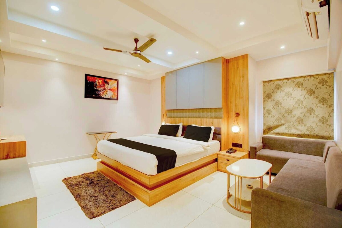 A modern bedroom with a bed, bedside table, and a small round table.