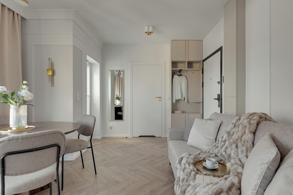 Una sala de estar moderna con comedor, un sofá, una mesa de centro y un espejo.