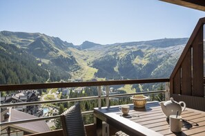 A balcony with a table, chairs, and a view of a mountainous landscape. - Wifi, 5m from ski slopes, view mountain, swimming pool, sauna, hammam, balcony, ski locker, 54m² (Arâches-la-Frasse)