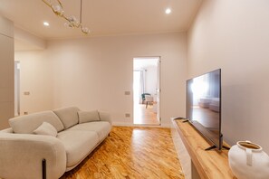 A modern living room with a sofa, a flat-screen TV, and a wooden floor. - Classic Prati Living (Rome)