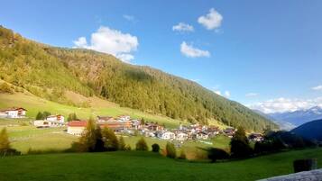 Ein Dorf eingebettet in ein Tal mit Häusern und einer Bergkulisse.