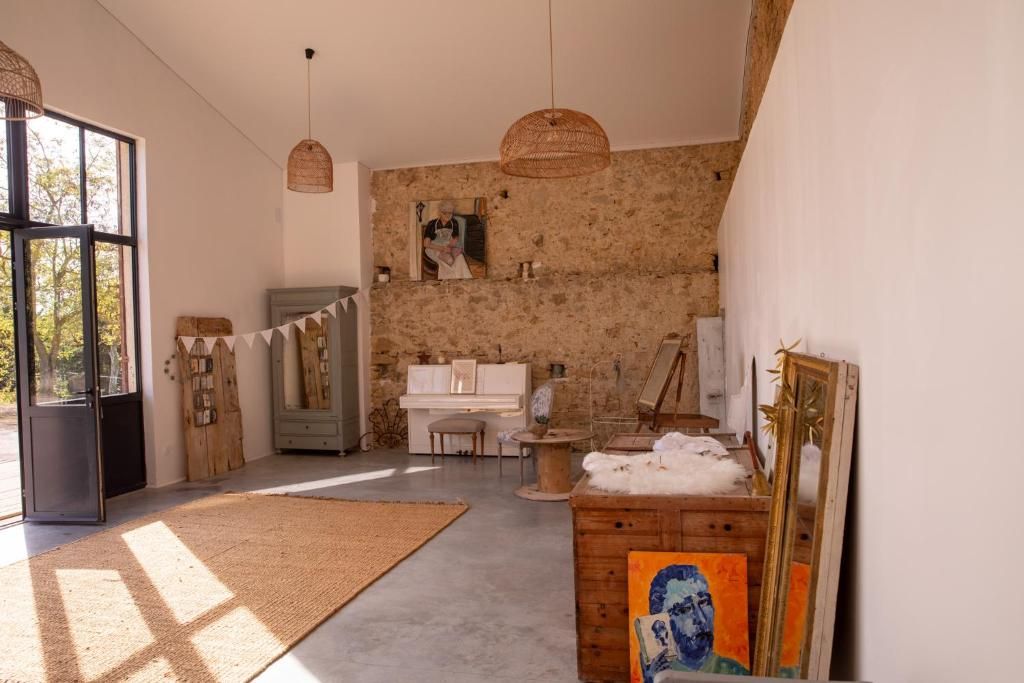 A room with a piano, a painting, and a rustic wall.