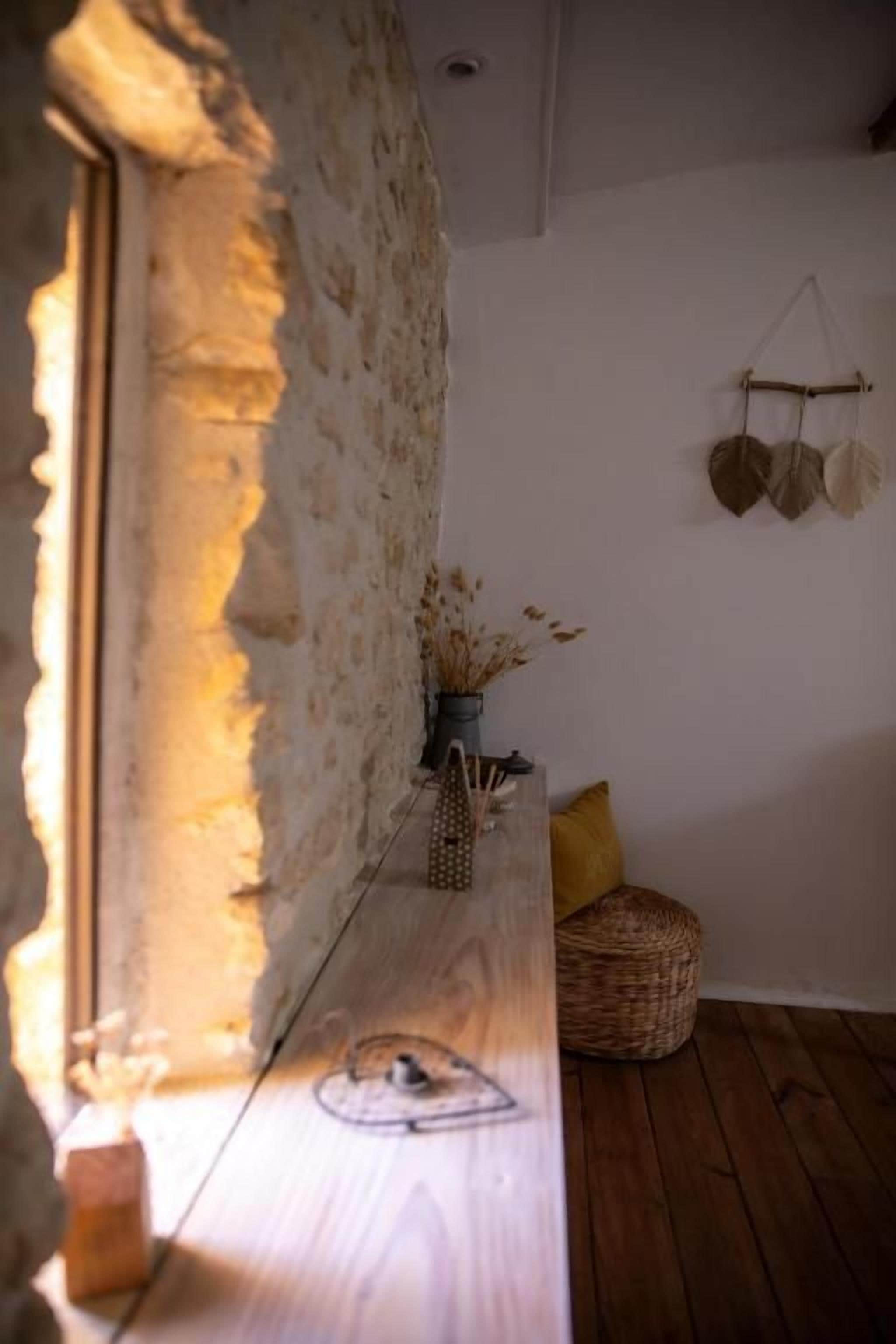 A rustic interior with a wooden bench, a stone wall, and a hanging light fixture.