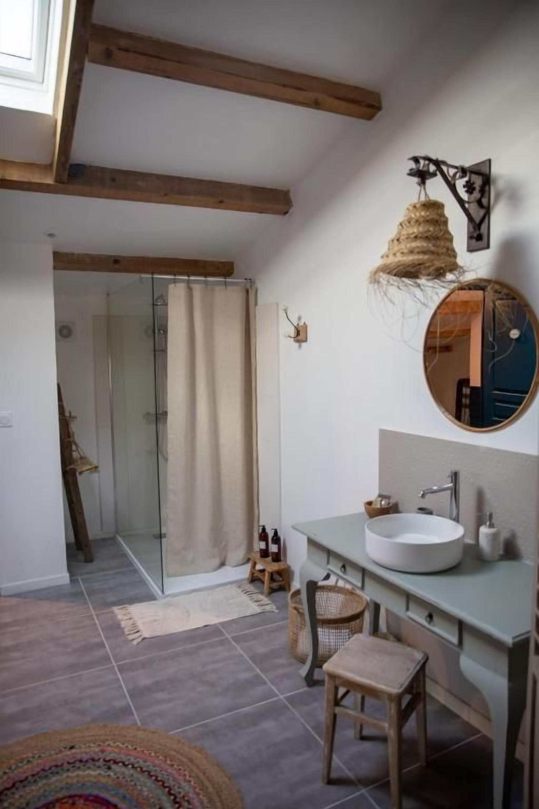 Un baño con un ventanal grande, un lavabo, un espejo y una zona de ducha.