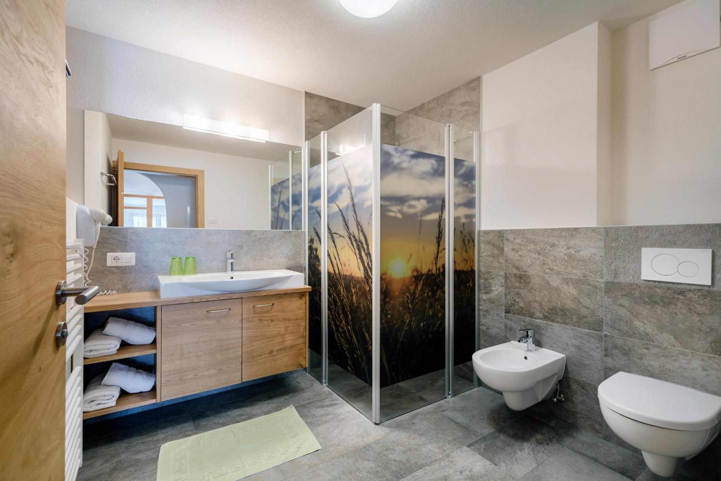 Ein modernes Badezimmer mit einem Holzlagerfläschchen, einer Duschkabine aus Glas und einem Bidet.