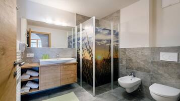 Ein modernes Badezimmer mit einem Holzlagerfläschchen, einer Duschkabine aus Glas und einem Bidet.