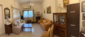 A living room with a sofa, a coffee table, a cabinet with glass doors, and a fireplace. - Country House 'Ochra' with Mountain View, Wi-Fi and Air Conditioning (δημοτική ενότητα Λουτρακίου-Περαχώρας)