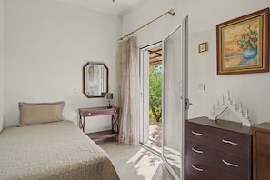 A bedroom with a bed, a dresser, a mirror, and a painting.