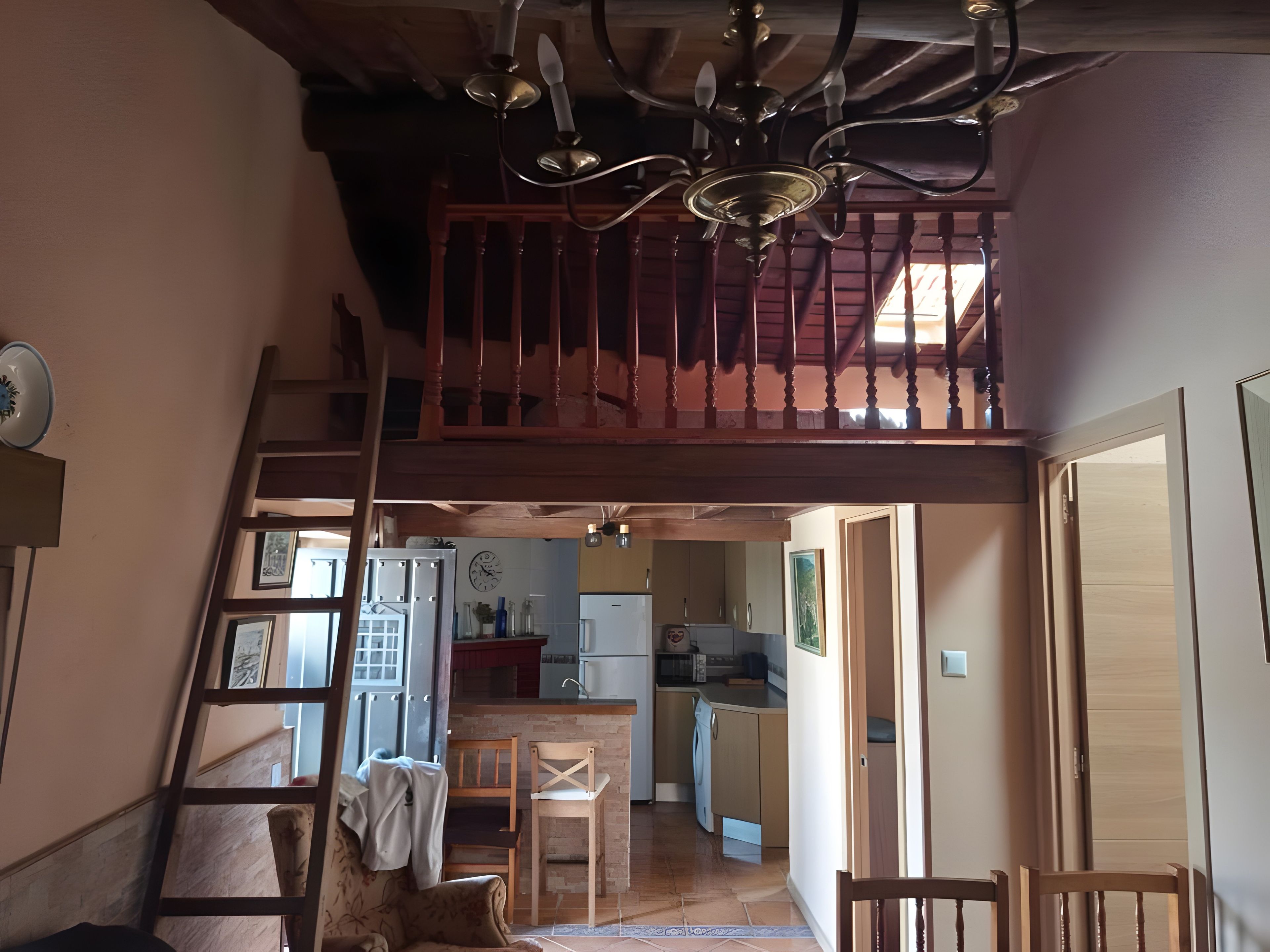 Un interior de varios niveles con una escalera, un comedor y una cocina.