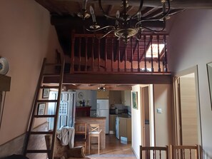 Ein mehrgeschossiges Interieur mit Treppe, Essbereich und Küche.