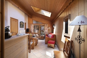 A cozy wooden interior with a dining area, a sofa, and a lamp. - Wifi, 50m from ski slopes, view building, fitness, swimming pool, sauna, hammam, balcony, ski locker (Les Arcs)