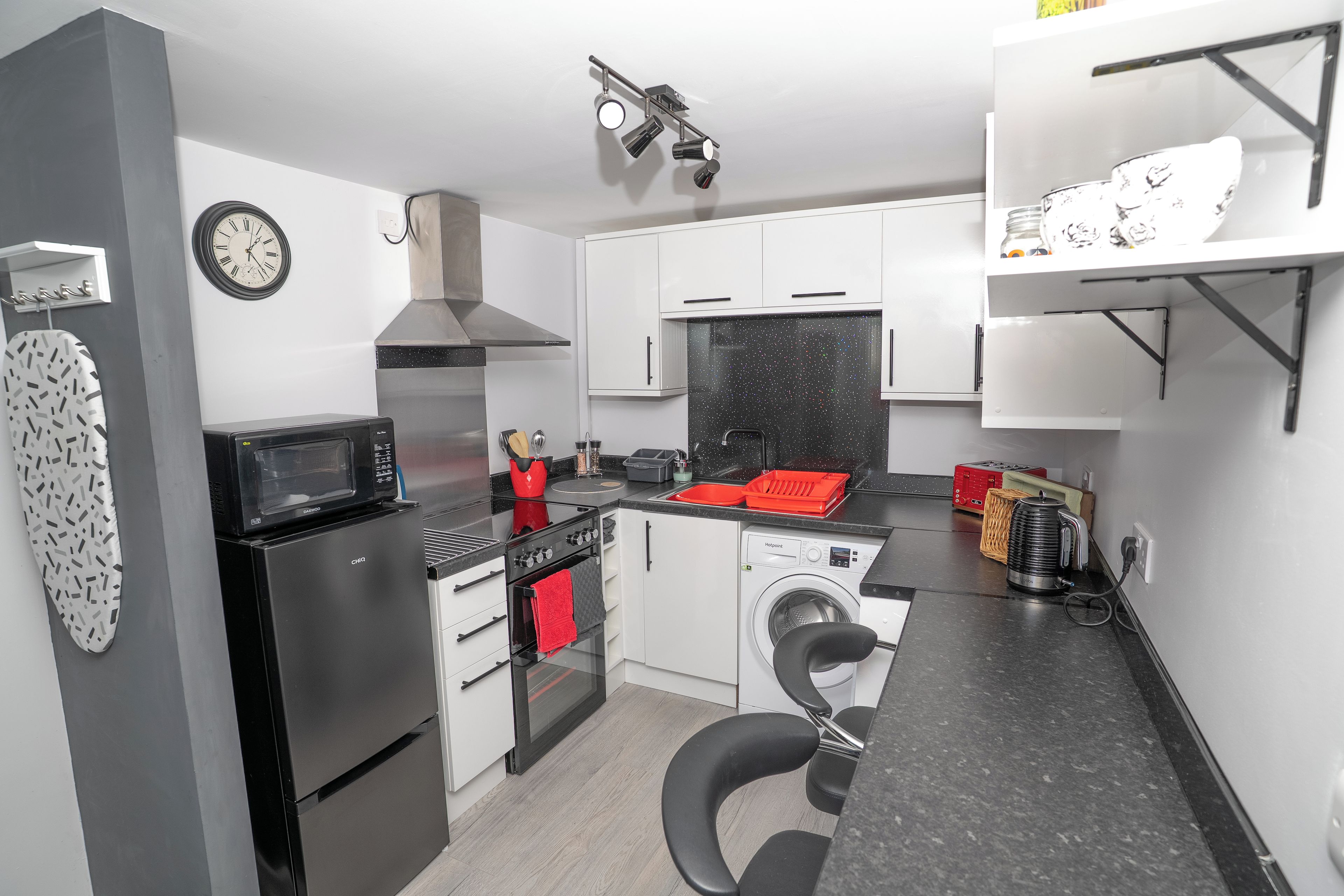 A compact kitchen with a microwave, stove, oven, and washing machine.