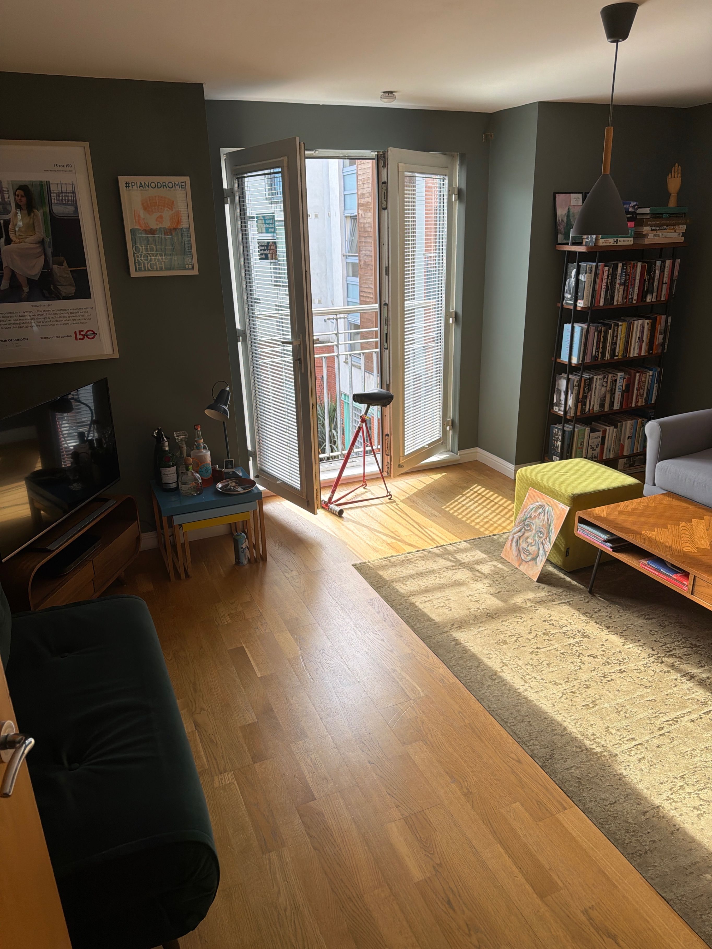 A living room with a sofa, a coffee table, a bookshelf, and a painting.