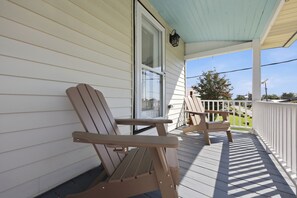 A porch with two wooden Adirondack chairs and a white railing. - Historic Swansboro Retreat | Water Views + Backyard with Pizza Oven (Swansboro)