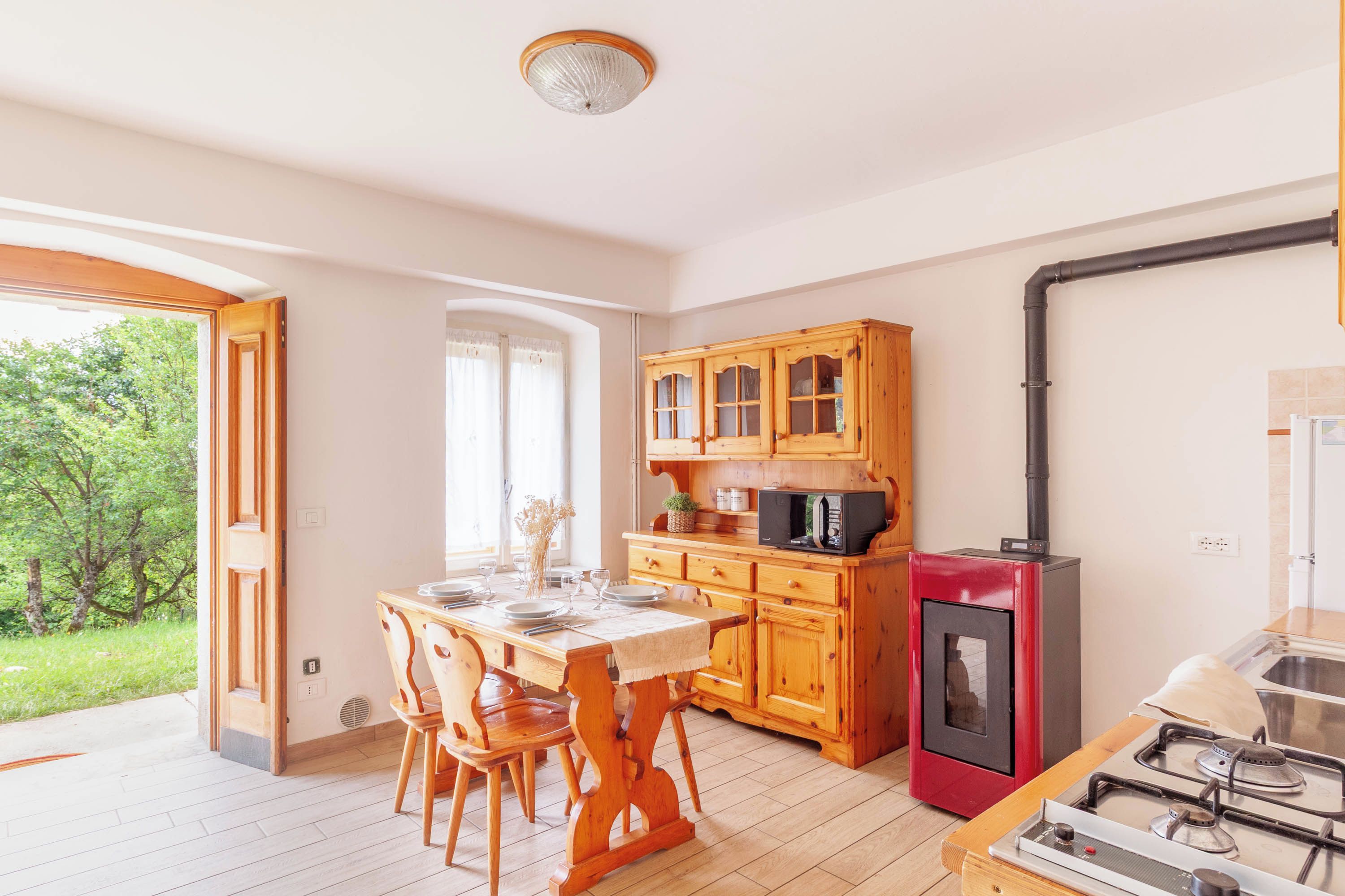 Una cocina con gabinetes de madera, estufa a gas y microondas.