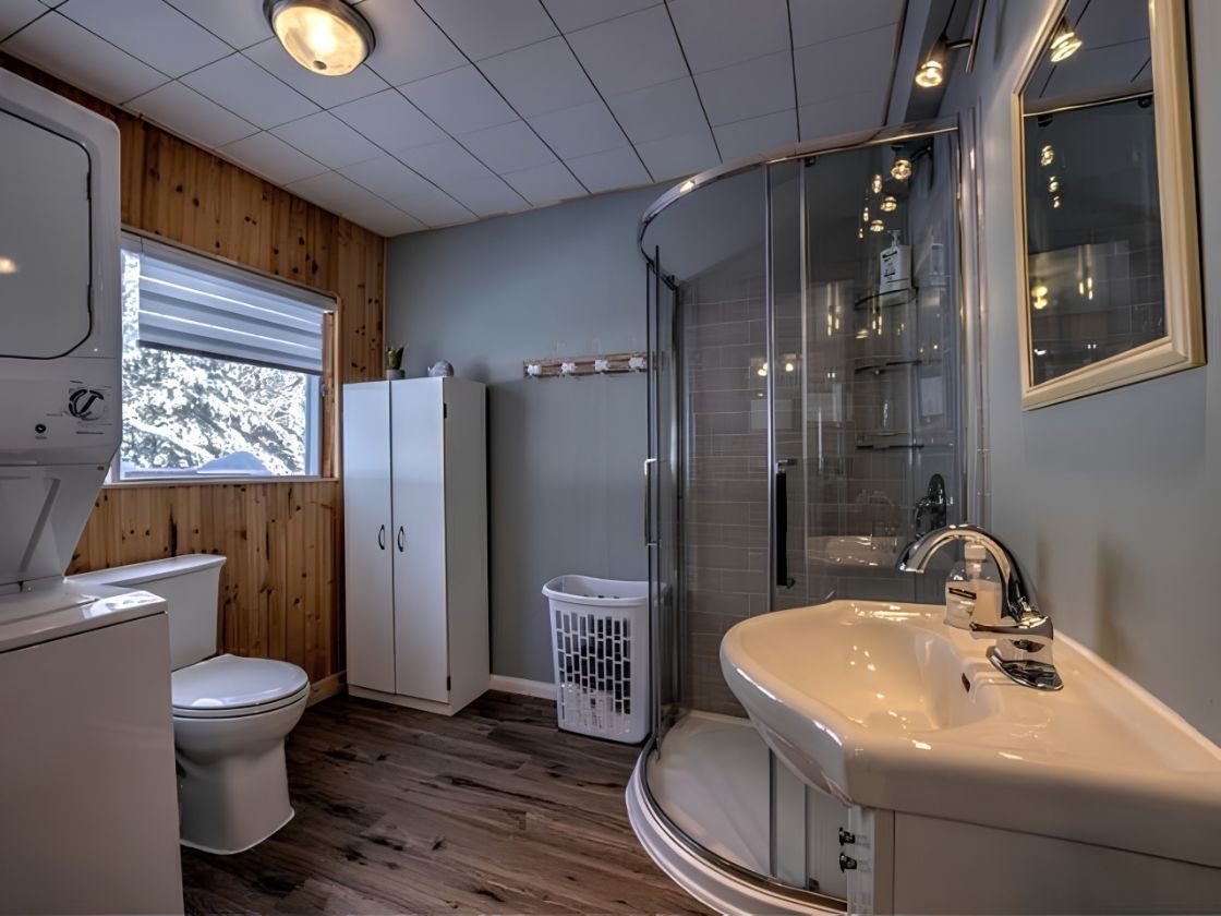 Une salle de bain comprenant des toilettes, un lavabo, un espace douche et une fenêtre.