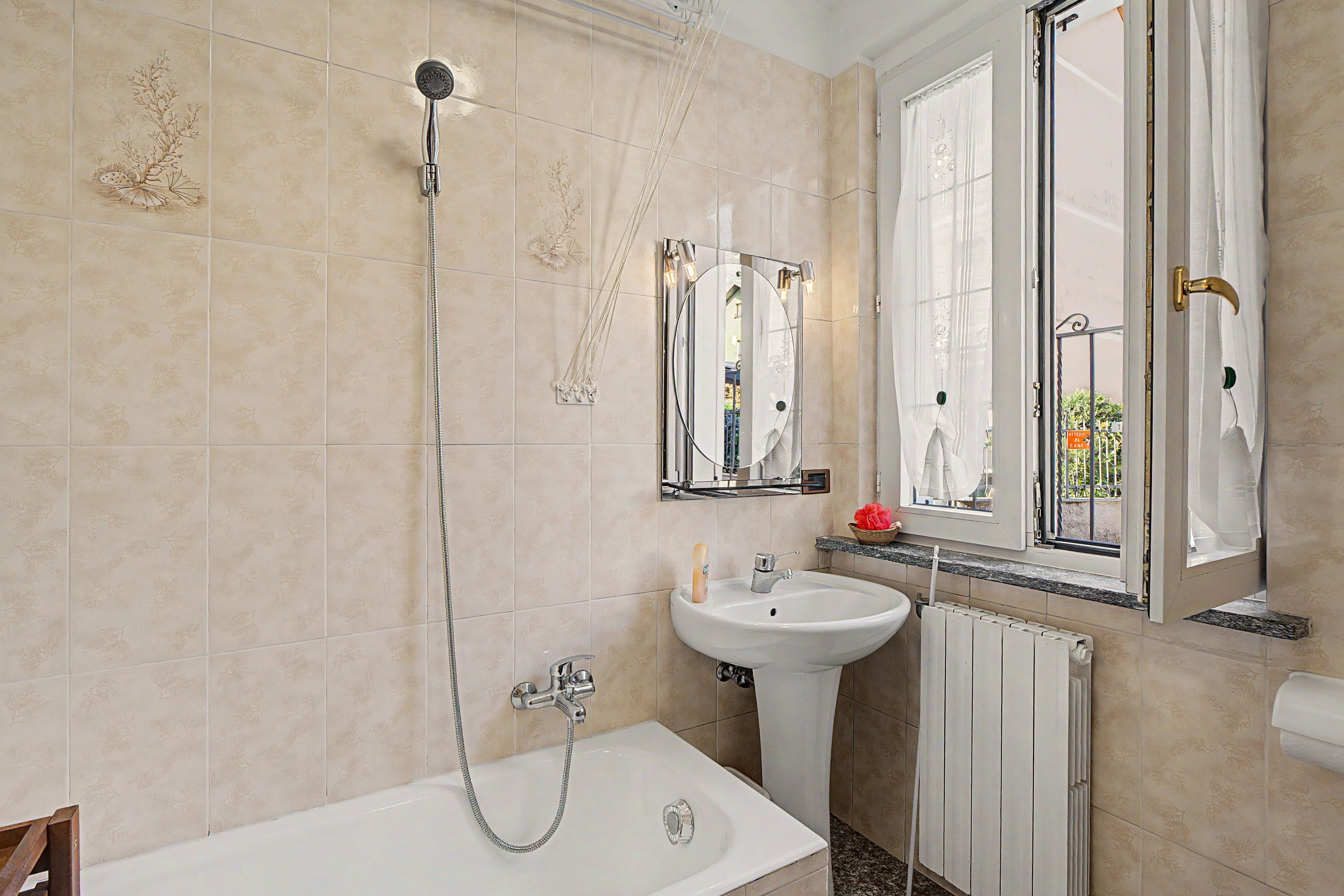 A bathroom with a bathtub, a sink, a mirror, and a shower.