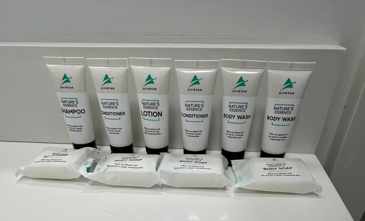 A display of Avistar Nature's Essence products including shampoo, conditioner, lotion, body wash, and body soap.