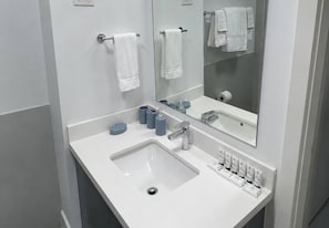 A modern bathroom with a white sink, a mirror, and a towel rack. - Sol Harbour Apartment in Ocho Rios (Ocho Rios)