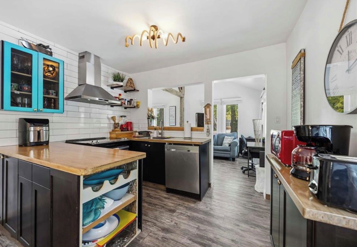 A modern kitchen with a central island, built-in cabinets, and a dining area with a sofa.