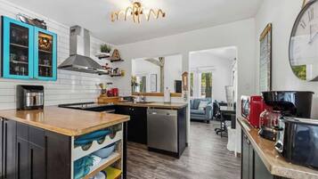 A modern kitchen with a central island, built-in cabinets, and a dining area with a sofa.