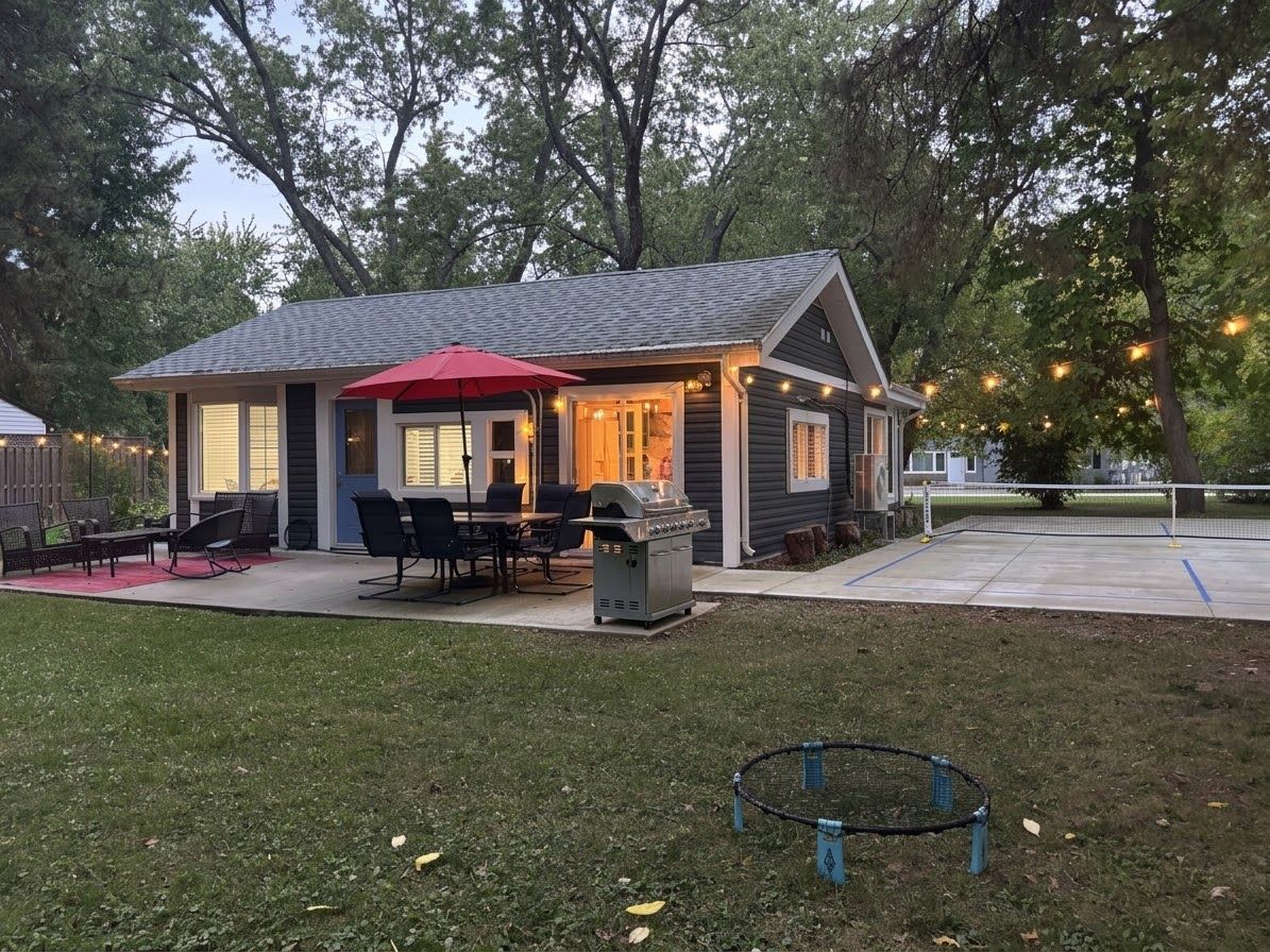 Una casa amb un pati, mobiliari exterior i una barbacoa.