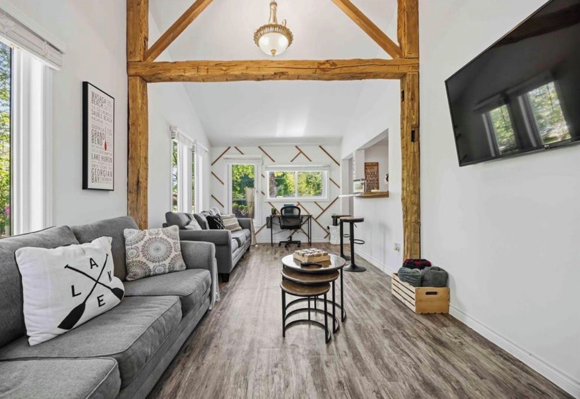 A modern living room with a grey sofa, a coffee table, and a wooden ceiling structure.