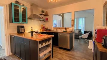 A modern kitchen with dark cabinetry, a central island, and a dishwasher.