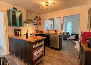 Una cuina moderna amb armaris foscos, una illa central i un rentaplats.