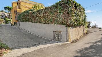Un edificio con fachada de hormigón, una puerta pequeña y un cartel con el número 112.