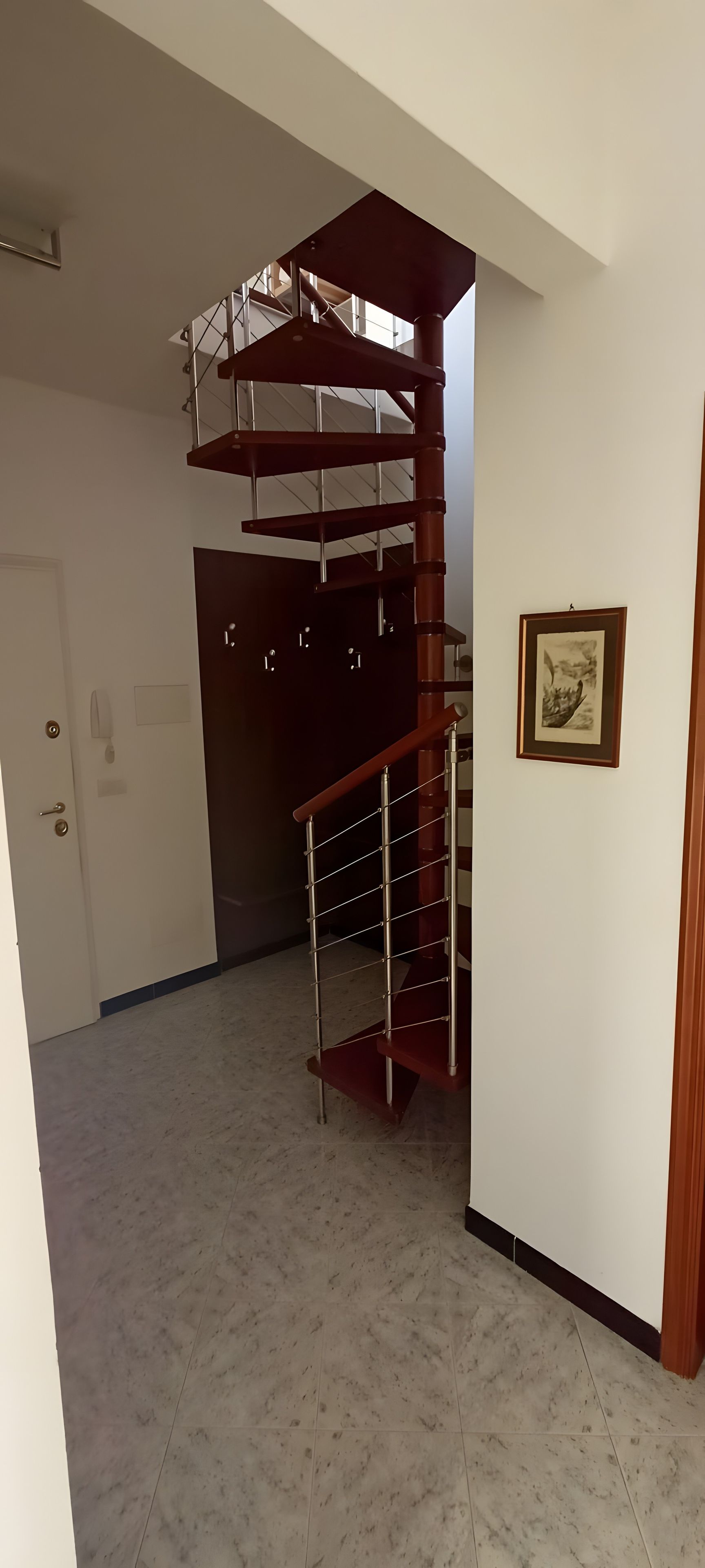 A spacious room with a spiral staircase leading to an upper floor.
